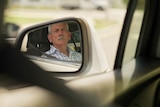 The reflection of John Quinn in the rear view mirror.