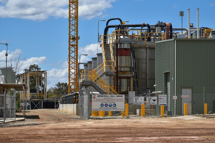 Une usine minière avec un hangar vert et un panneau indiquant Mine Mineral Hill