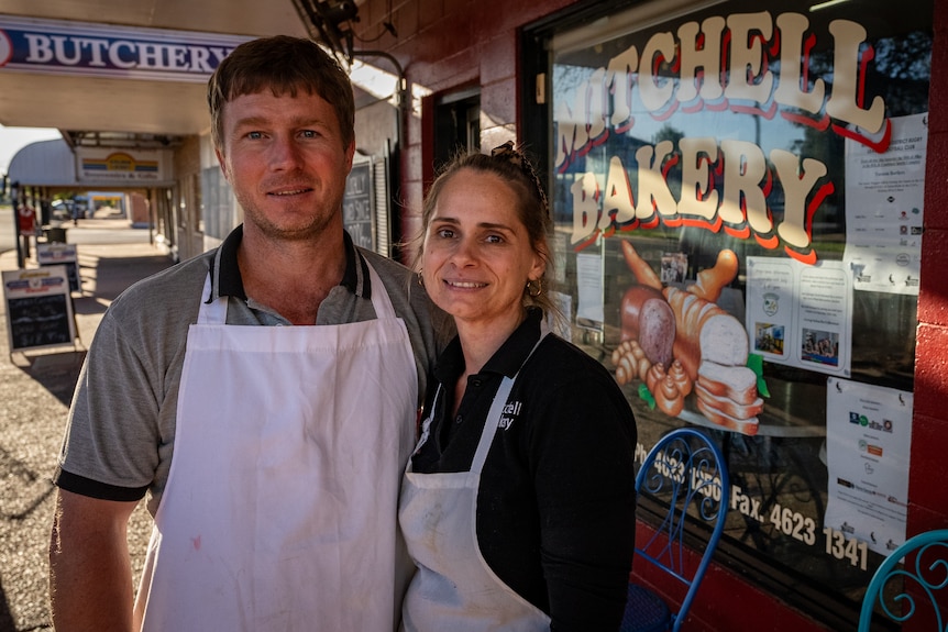 Image of a man and woman smiling in front of a bakery.
