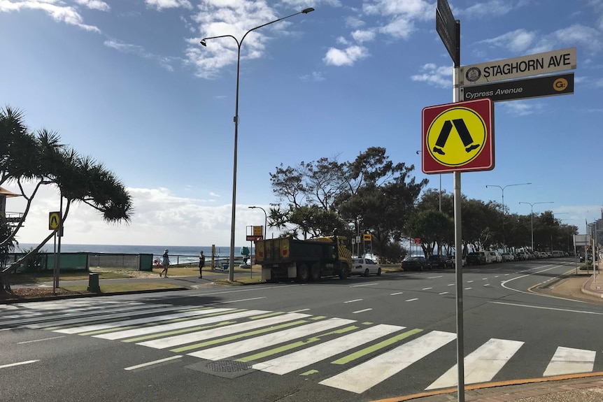 Street and street signs with beach in the distance, where toddler's body was found.