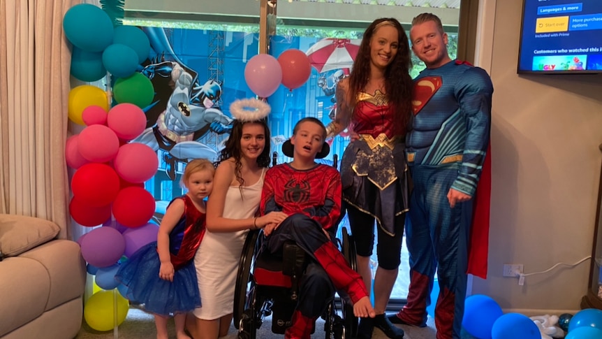 A family dressed in superhero costumes.