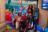 A family dressed in superhero costumes.