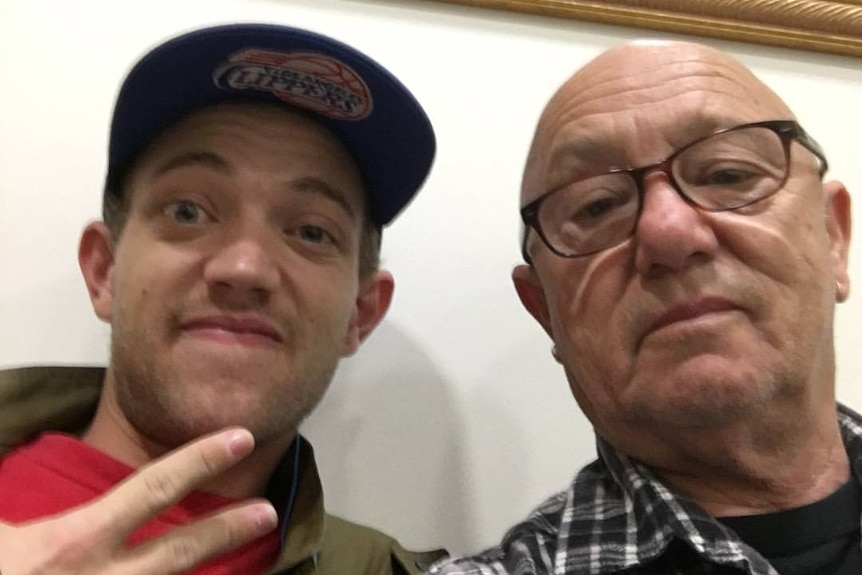 A young man in a cap with an older man in glasses