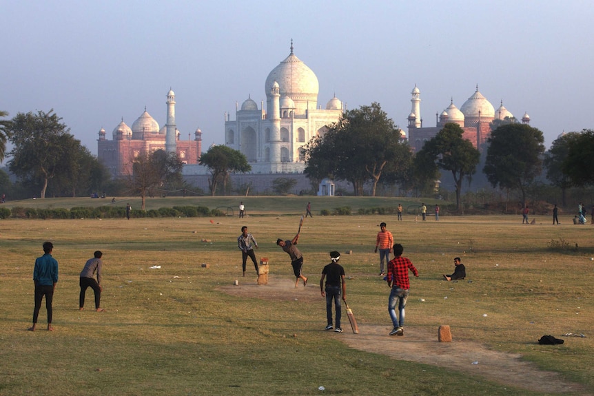 People play cricket in front of Taj Mahal.