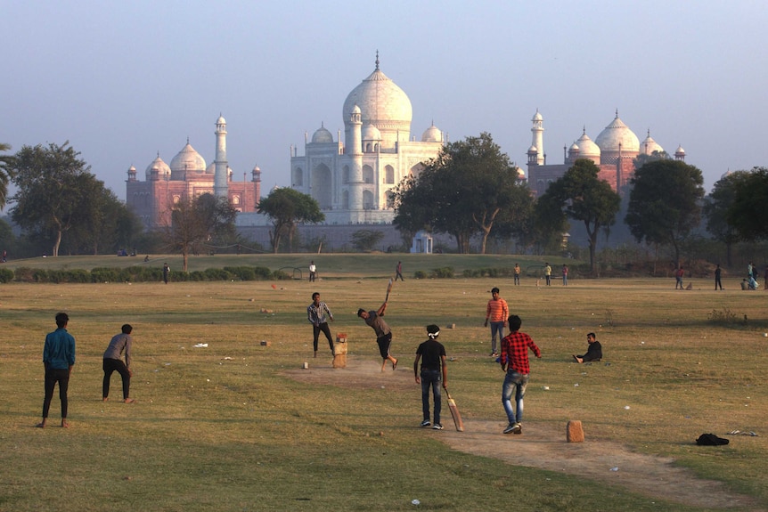 Les gens jouent au cricket devant le Taj Mahal.