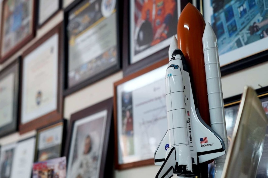 A model space shuttle, framed photos of astronauts, certificates and thank you letters mark the wall of Tony Hutchison's shack.