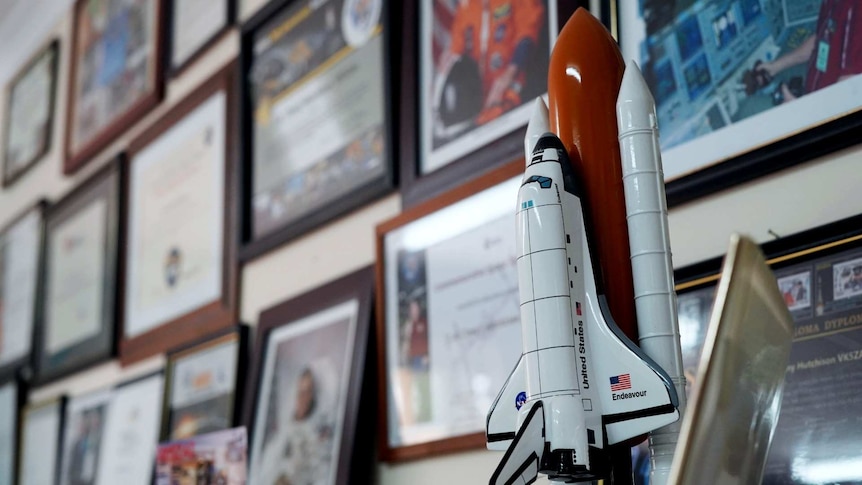 A model space shuttle, framed photos of astronauts, certificates and thank you letters mark the wall of Tony Hutchison's shack.