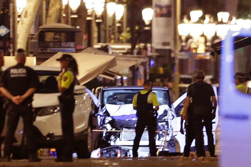 Police officers stand next to the van involved in the Las Ramblas attack.