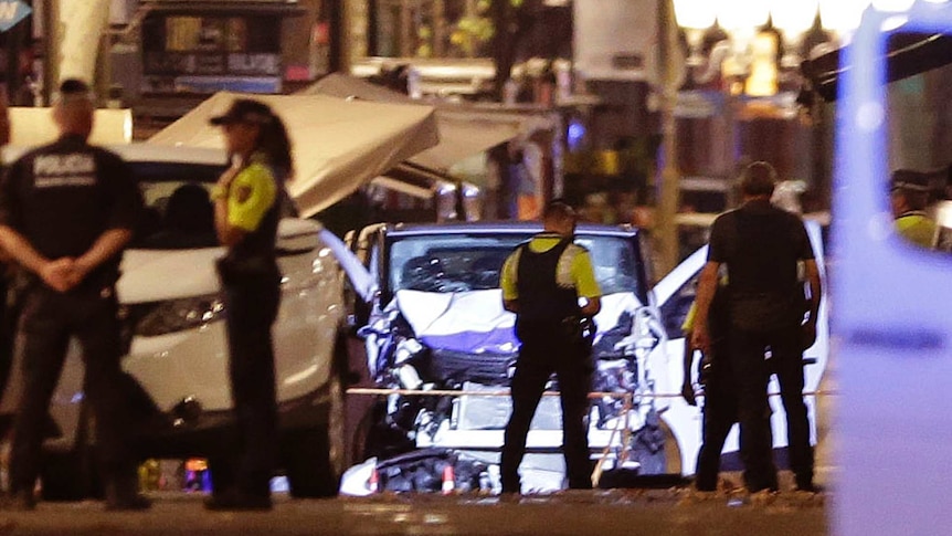 Police officers stand next to the van involved in the Las Ramblas attack.