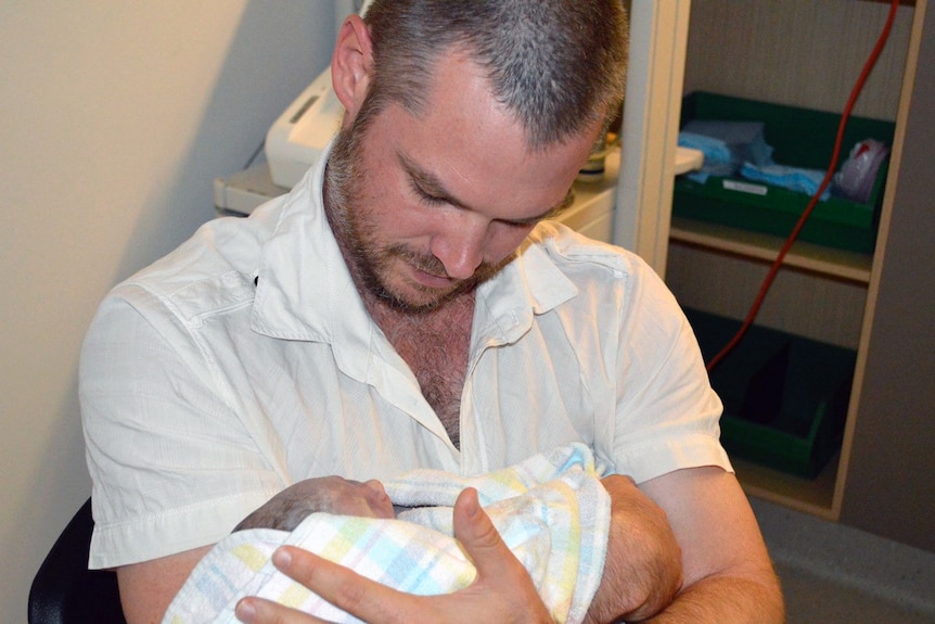 Mark Woods holds his daughter Claudia, who was stillborn.