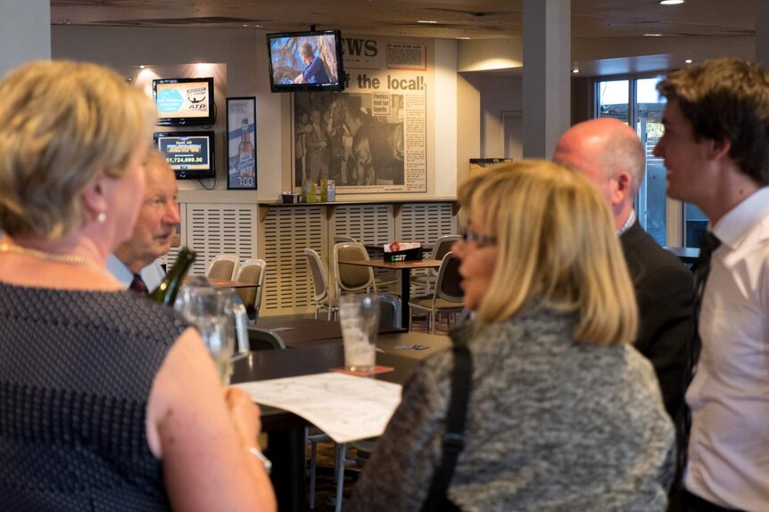 Patrons drink at Morphett Arms Hotel with Lord Reims article on wall in background.