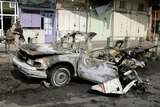 An Iraqi soldier inspects the wreckage of a vehicle used in a car bomb attack in Baghdad