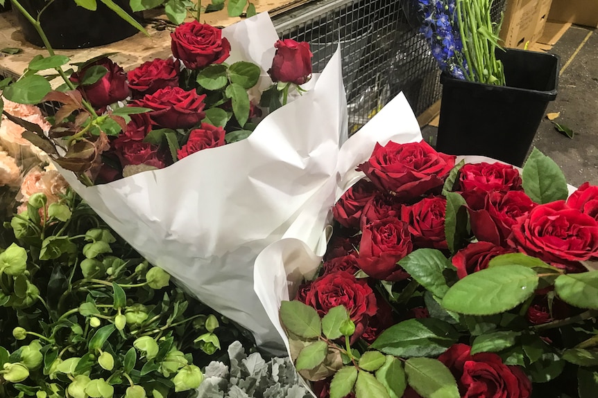 Bunches of roses are wrapped for sale at the Sydney Flower Market