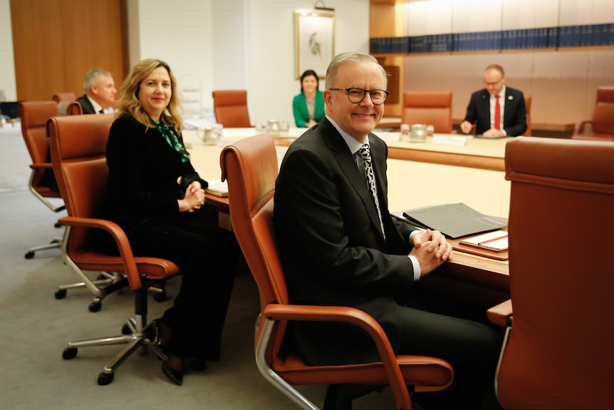 Albanese is twisting in his chair around towards the camera, Palaszczuk is behind him.