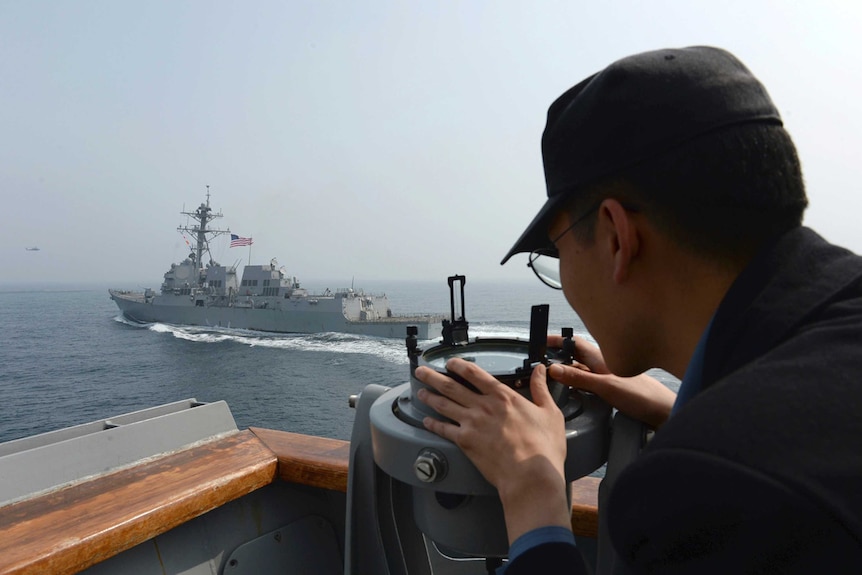 A man looks at the destroyer at a US vessel