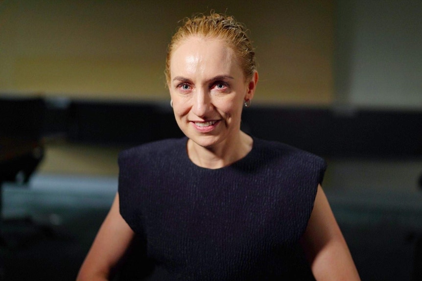 A woman wears a blue top.