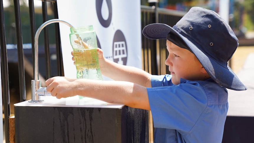 A primary school student fills water bottle from Source hydropanel tap