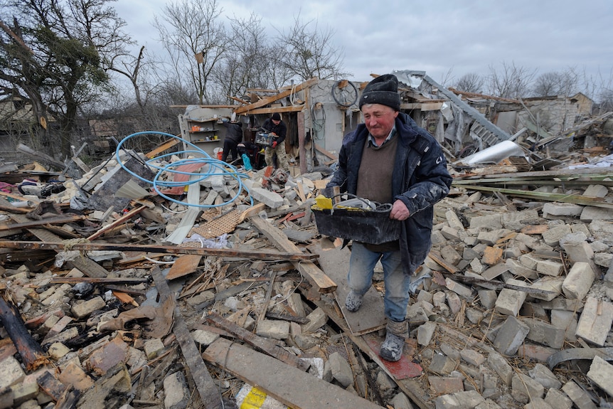 Villagers clear the rubble from destroyed homes.