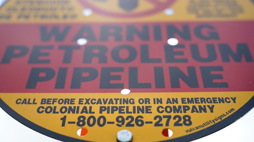 A red and yellow sign that reads "warning petroleum pipeline".