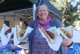 Woman holds four sausages on bread