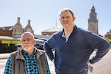 Two men standing on the street in Kalgoorlie with historic buildings behind them