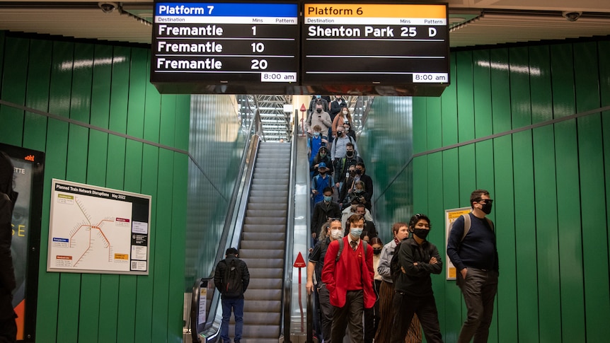 People wearing masks as they come down the escalator in the Perth underground