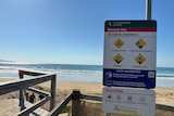 photo of a beach and safety sign
