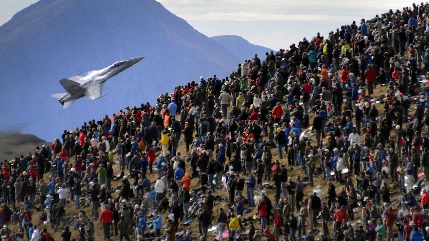 Crowd watches Swiss Air Force flight demonstration.