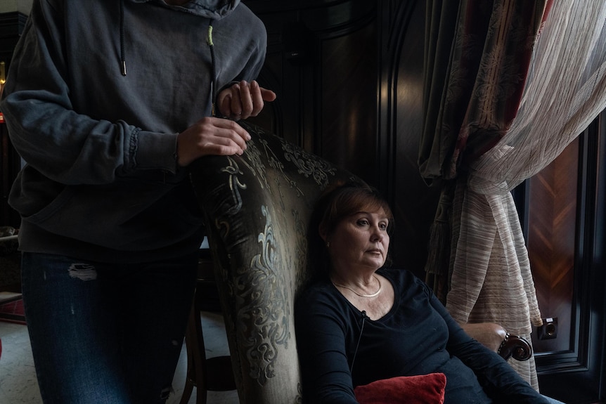 A woman leans back in a chair.