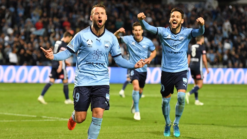 A football player celebrates a goal with teammates