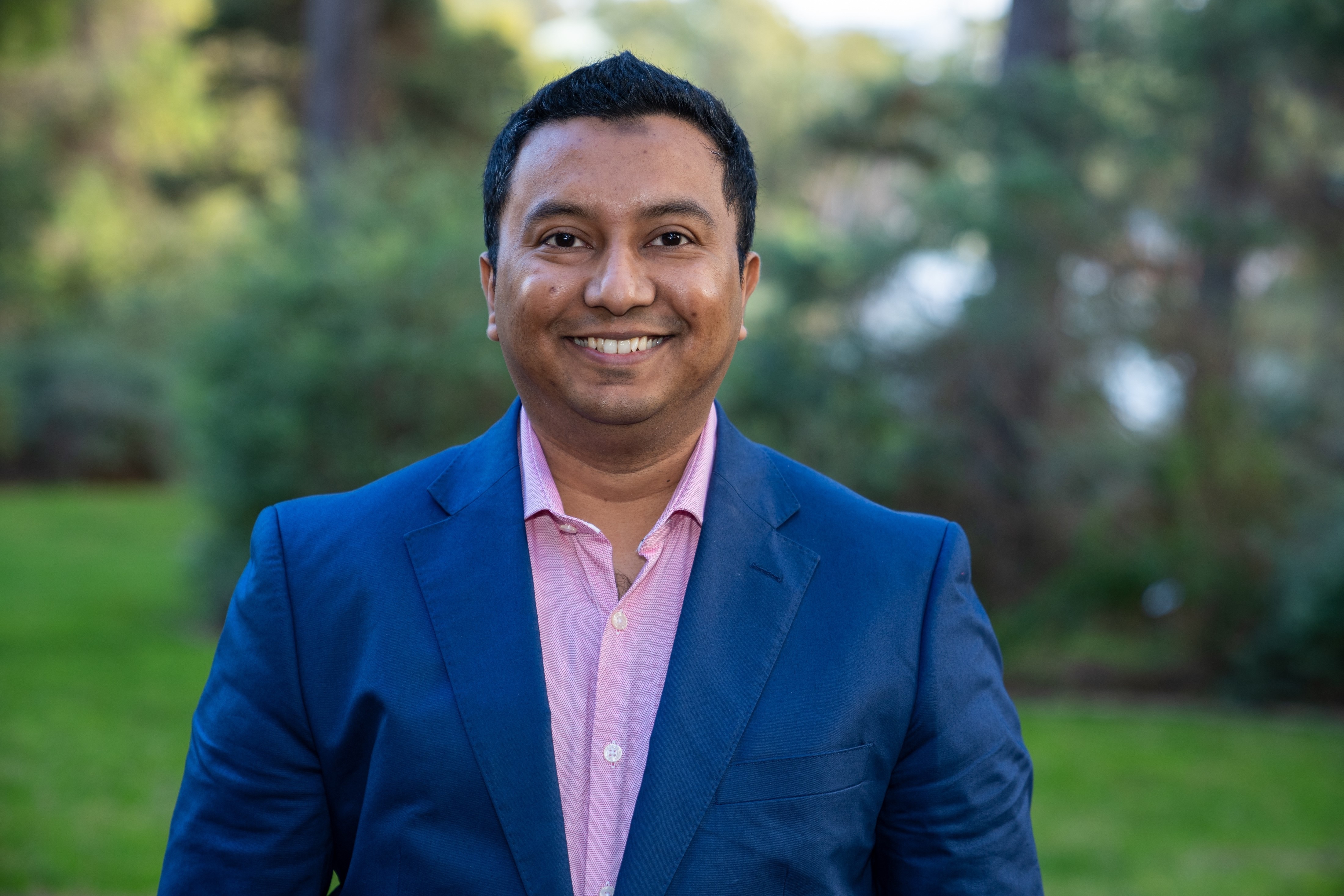 Close up of Dr Ahmed wearing a navy suit.
