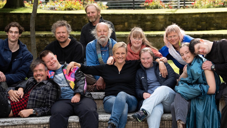 A group of smiling people sitting on a bench 