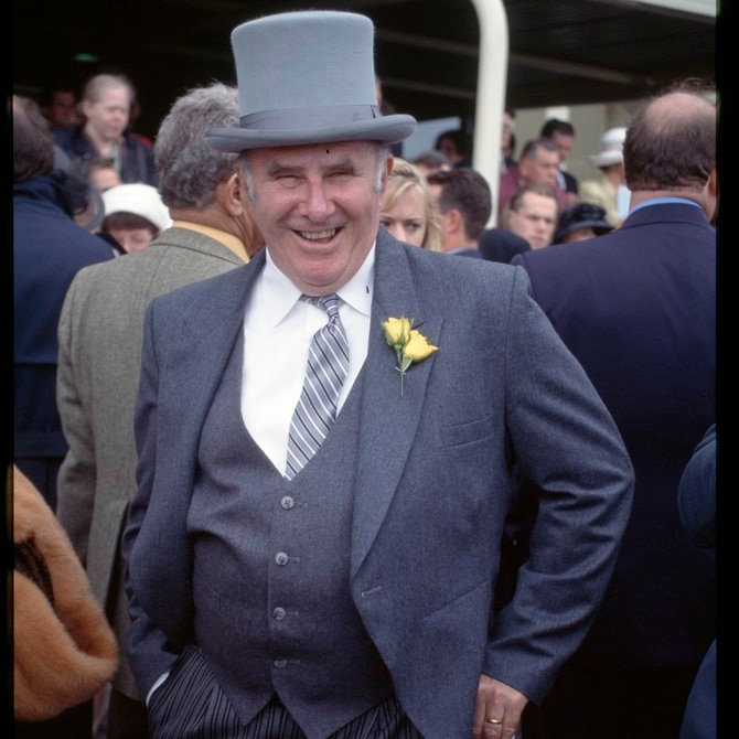 Man in top hat and with yellow rose in his buttonhole