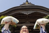 Yamamotoyama poses with rice bags