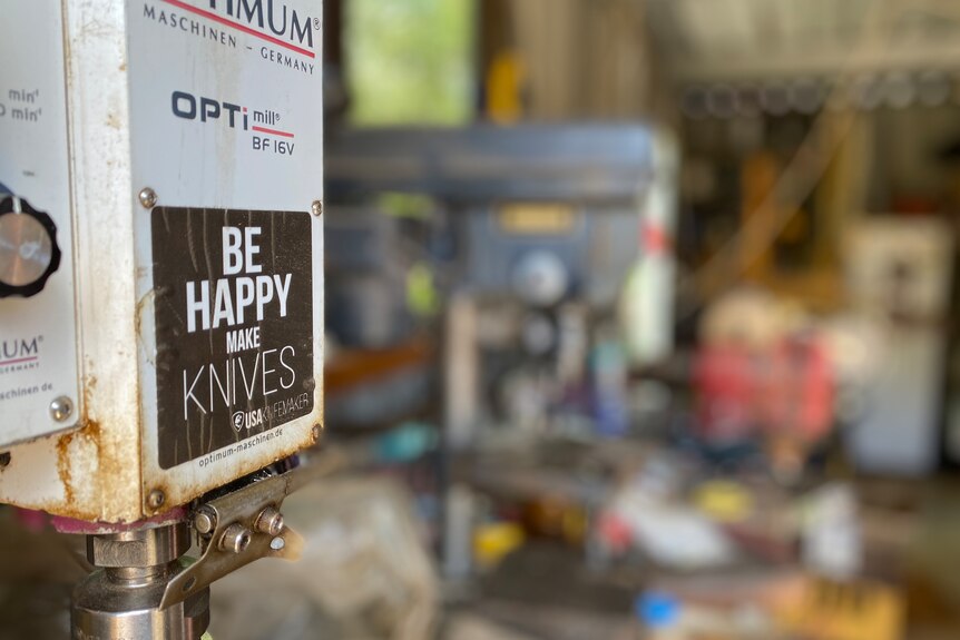 A workshop with a label on a box that reads: "Be happy, make knives".
