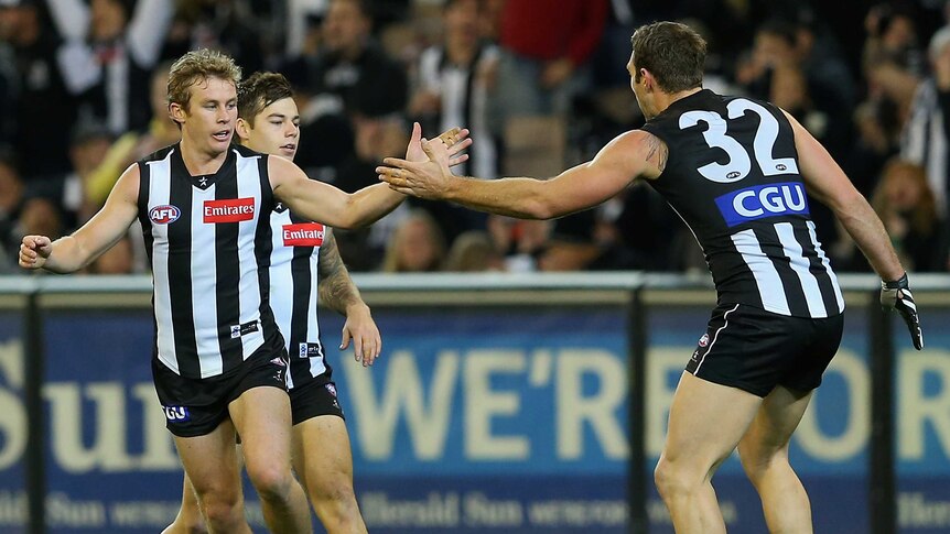 Travis Cloke (R) congratulates Sam Dwyer for his goal for the Magpies against Geelong.