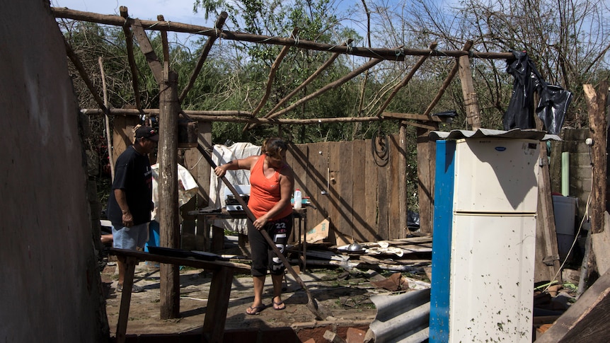 A local resident begins cleaning her wrecked house after hurricane Patricia.