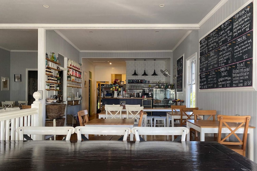 The interior of Jam Cafe showing wood tables and whit chairs.