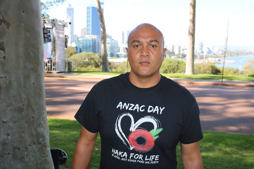 Leon Ruri, event organiser wears a black shirt in a park.