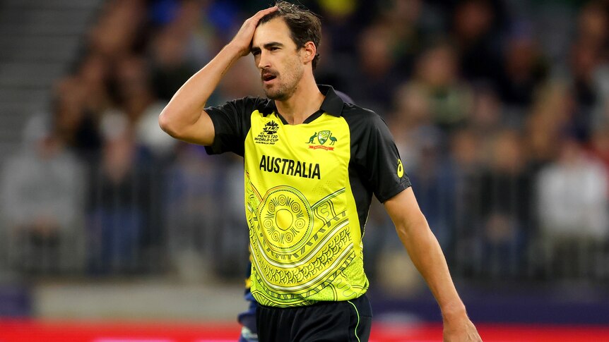 Mitchell Starc looks frustrated as he holds one hand on his forehead after bowling