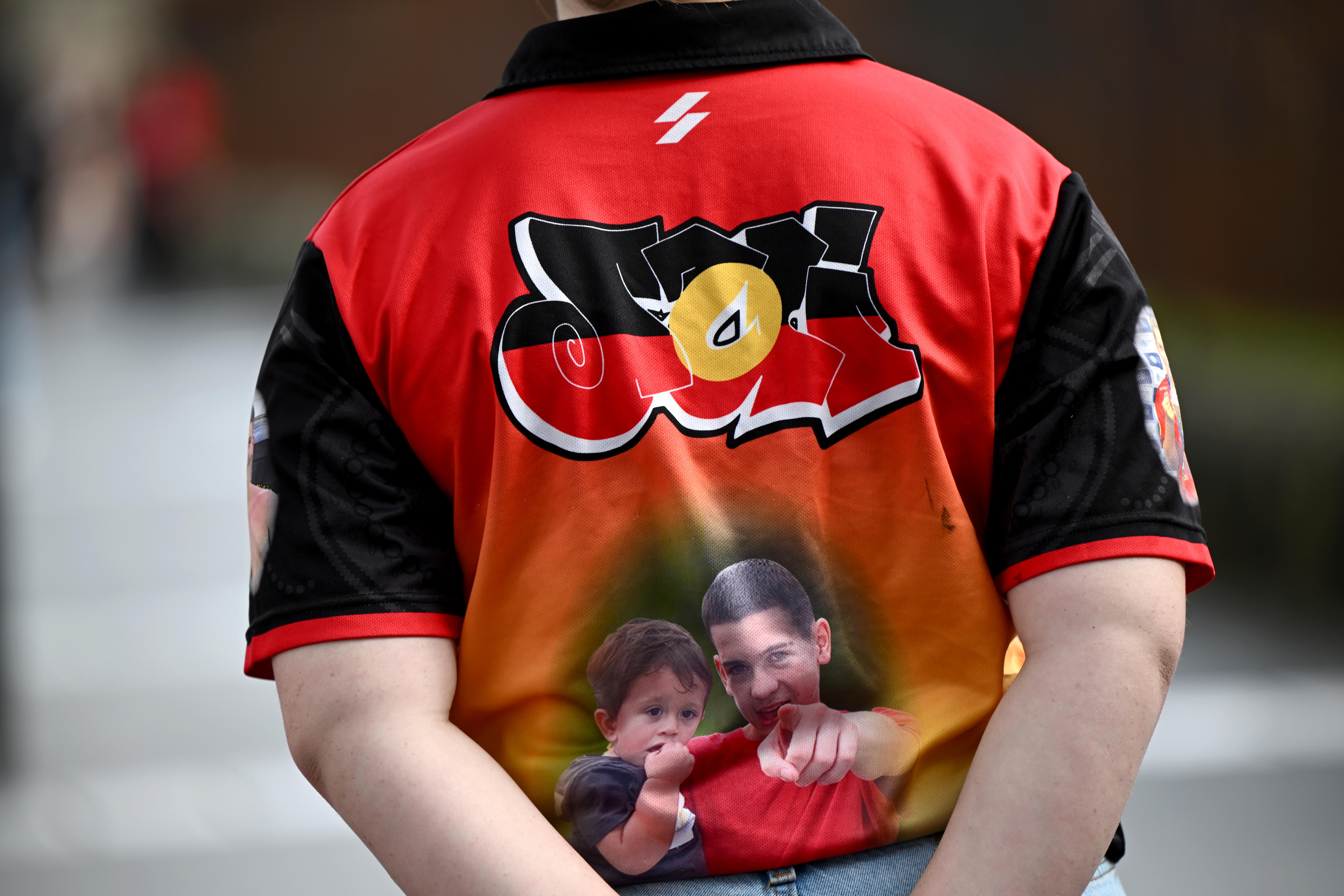 red jerseys with the word 'jai' coloured in the the aboriginal flag