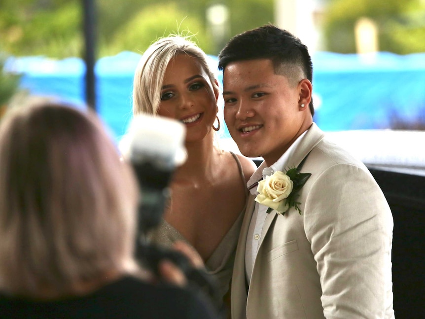 A man and a woman smile at a photographer.