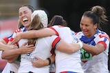 Newcastle Knights NRLW players hug during the grand final against the Parramatta Eels.