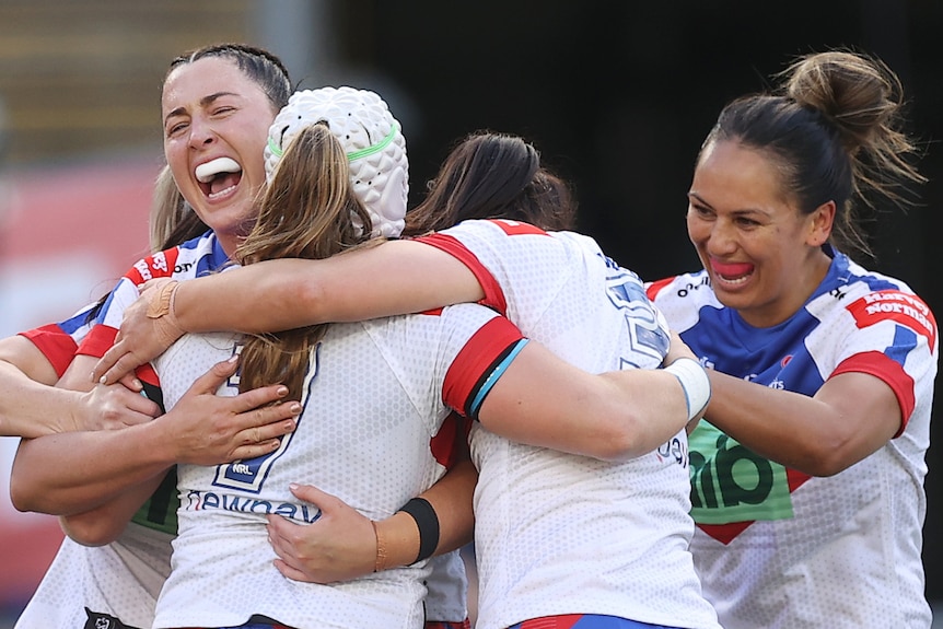 Newcastle Knights NRLW players hug during the grand final against the Parramatta Eels.