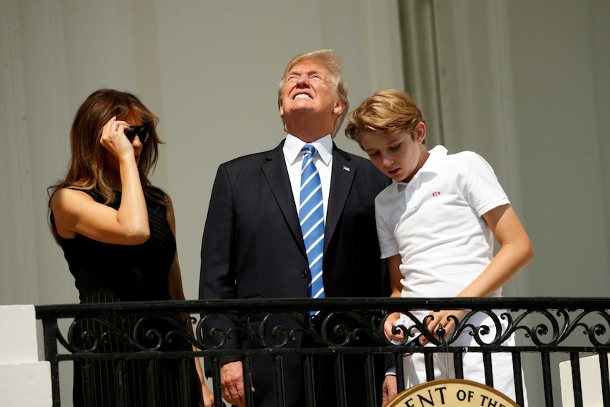 US President Donald Trump looks up towards the solar eclipse without his protective glasses