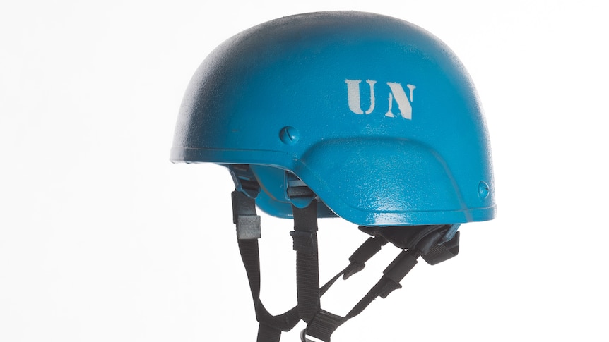 A bright blue hard hat with U.N. printed on the helmet indicating a United Nations peace keeper. 