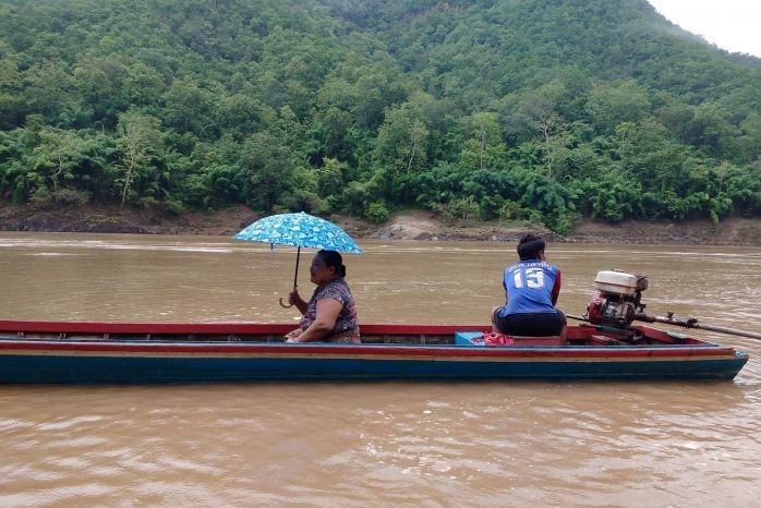 Karen woman and man travelling down the Sarween river.