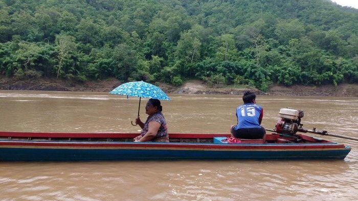 Karen woman and man travelling down the Sarween river.