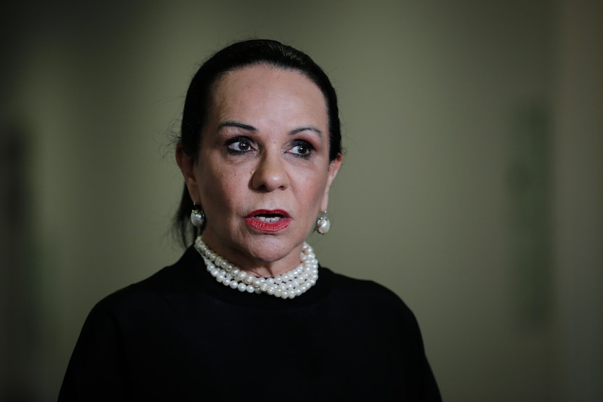 Linda Burney, wearing black with pearls on the national day of mourning, with a blurred out background