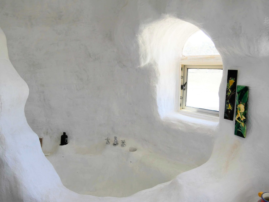 A white room with curved walls and a window.
